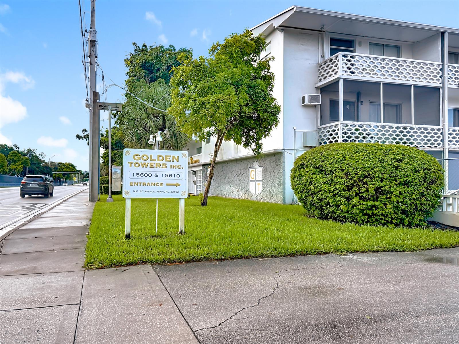 A white apartment building stands behind a sign for Golden Towers Inc. on a lawn — 15610 NE 6th Avenue # 37b, Miami FL 33162, MIAMI, FL