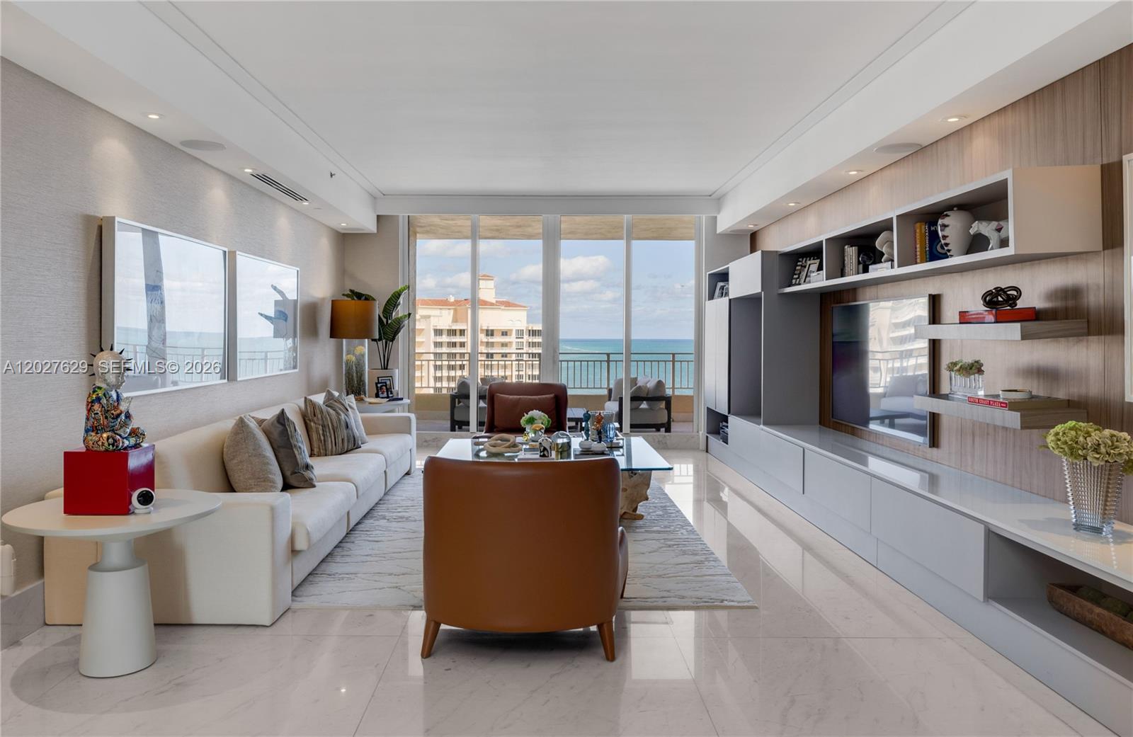 A modern living room features a white sofa, leather armchairs, and a large ocean-view balcony — 799 Crandon Blvd # 8, Key Biscayne FL 33149, KEY BISCAYNE, FL