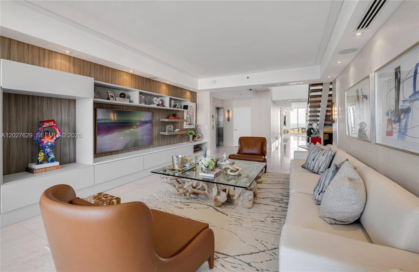 A modern living room features a large television, leather armchairs, and a driftwood coffee table — 799 Crandon Blvd # 8, Key Biscayne FL 33149, KEY BISCAYNE, FL