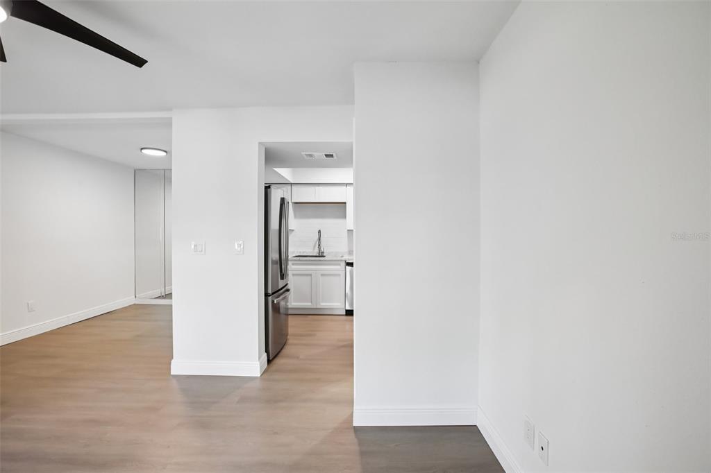 A view from a living area looking into a kitchen with white cabinets and appliances — 2906 LICHEN LANE UNIT B, CLEARWATER, FL