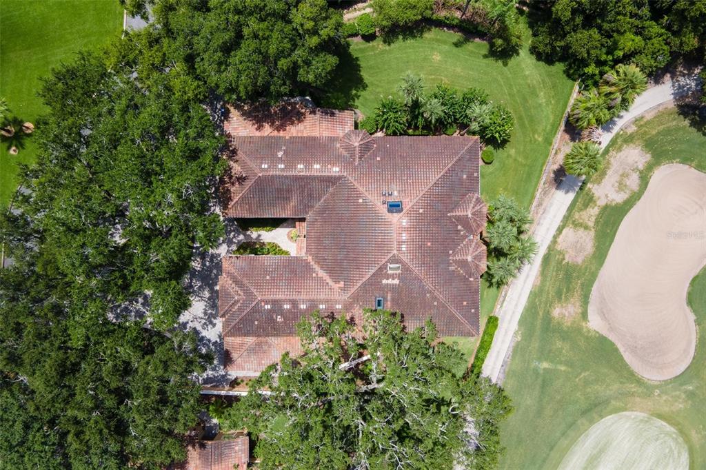 An aerial view of a large house with a tiled roof surrounded by trees and landscaping — 14 CAMINO REAL BOULEVARD UNIT 14, HOWEY IN THE HILLS, FL