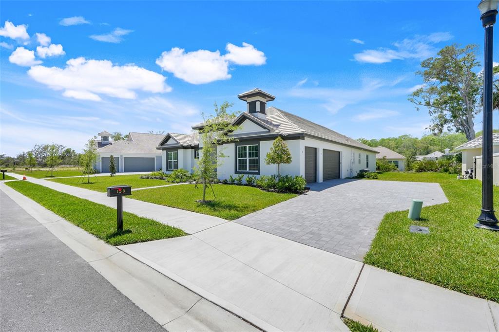 A single-story house with a white exterior, a tiled roof, and a paved driveway — 138 NEW LEATHERWOOD DRIVE, PALM COAST, FL