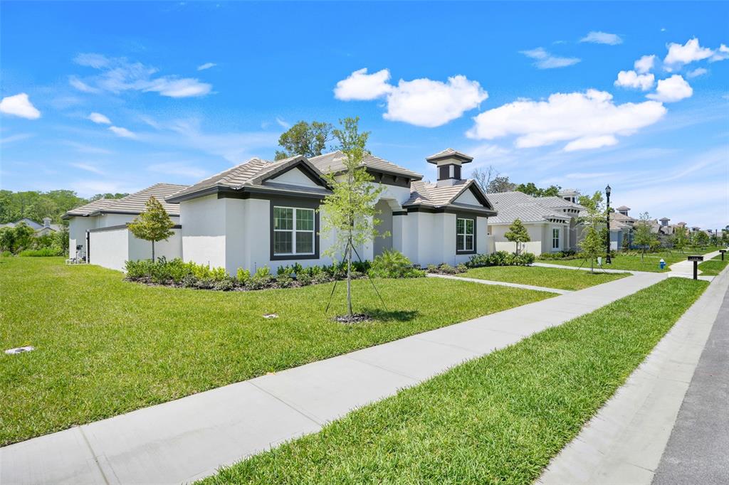 A single-story white stucco house with a tiled roof and a front lawn — 138 NEW LEATHERWOOD DRIVE, PALM COAST, FL