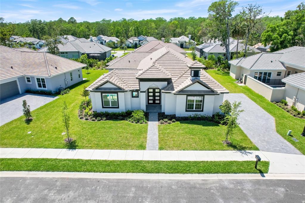 An aerial view of a single-story house with a tiled roof and a paved driveway — 138 NEW LEATHERWOOD DRIVE, PALM COAST, FL