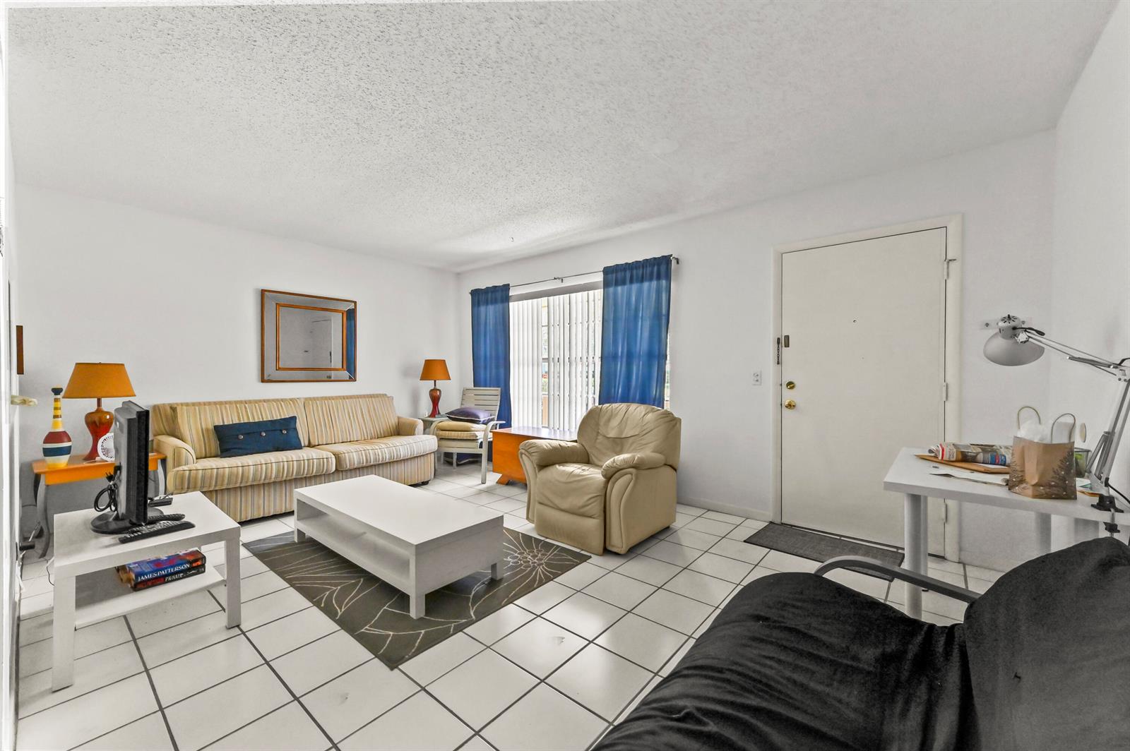 A living room features white tile floors, a striped sofa, a recliner, and a desk — 631 Snug Harbor Drive # S1, Boynton Beach FL 33435, BOYNTON BEACH, FL