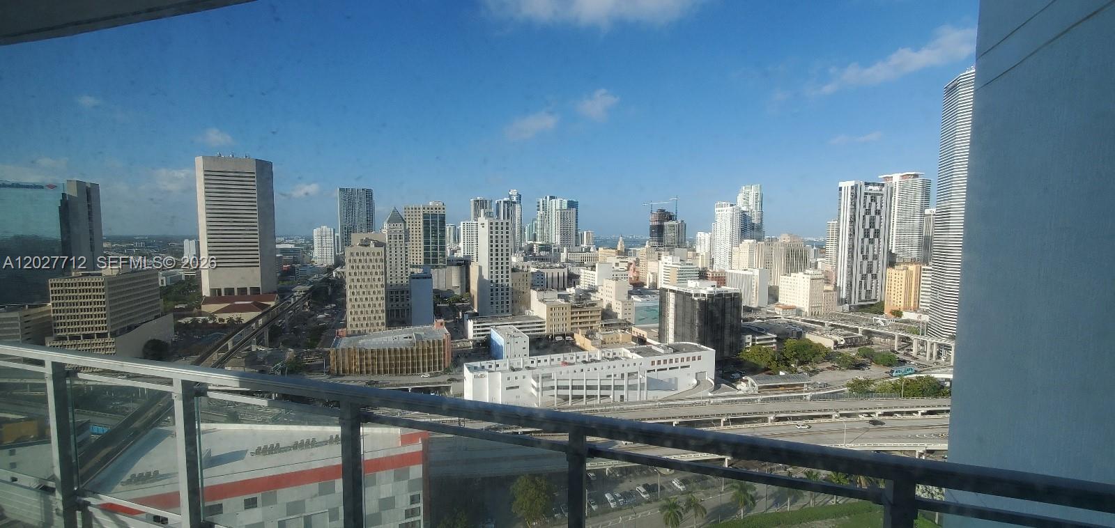 A high-angle view of the Miami skyline from a balcony with a glass railing — 90 SW 3rd St # 2705, Miami FL 33130, MIAMI, FL