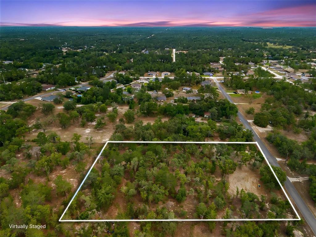 An aerial view shows a rectangular, wooded vacant lot outlined in white — 12055 FINCH ROAD, WEEKI WACHEE, FL