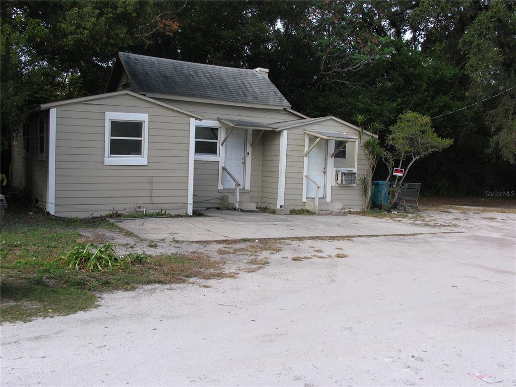 A small, single-story house with tan siding and two separate front entrances — 1020 AVONDALE AVENUE, ORLANDO, FL