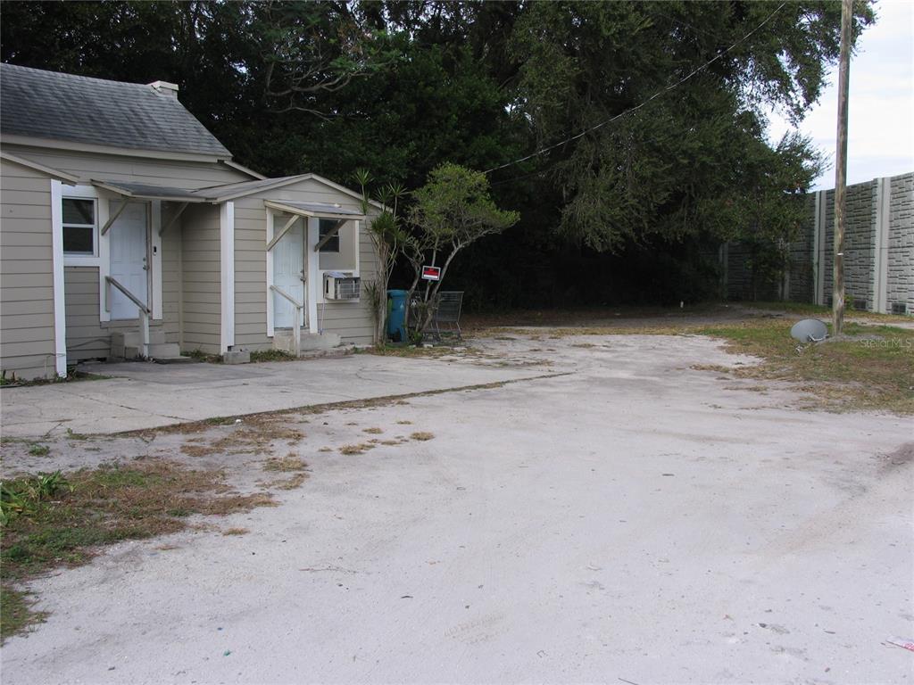 A beige house with two doors and a large, unpaved dirt and concrete parking area — 1020 AVONDALE AVENUE, ORLANDO, FL