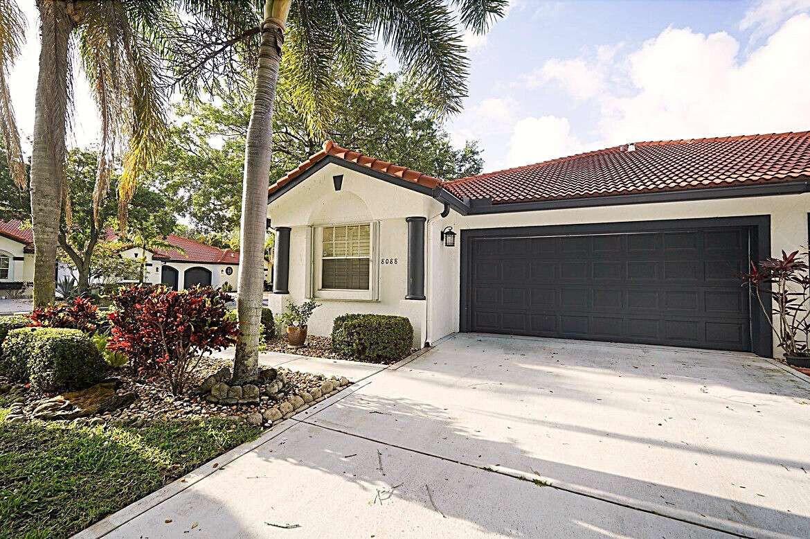 A single-story house with a white stucco facade, red tile roof, and a dark garage — 8088 Vía Di Veneto, Boca Raton FL 33496, BOCA RATON, FL