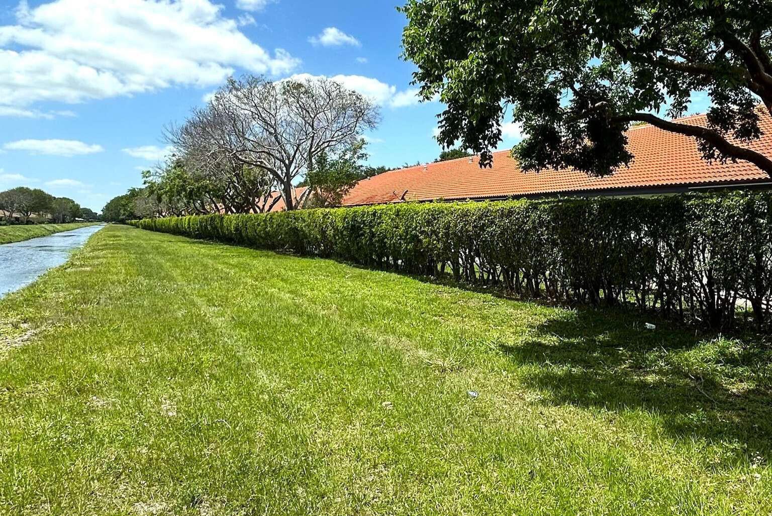A paved street is lined with mature trees forming a canopy over the road — 8088 Vía Di Veneto, Boca Raton FL 33496, BOCA RATON, FL