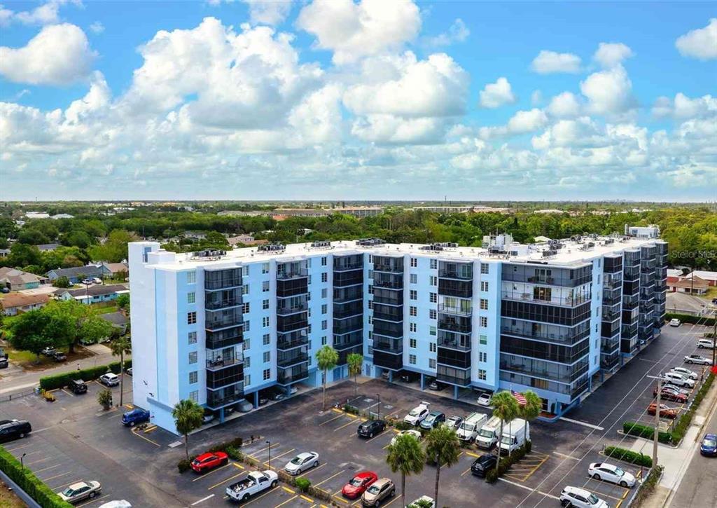A multi-story apartment building with screened balconies overlooks a paved parking lot — 2901 26TH STREET W UNIT 309, BRADENTON, FL