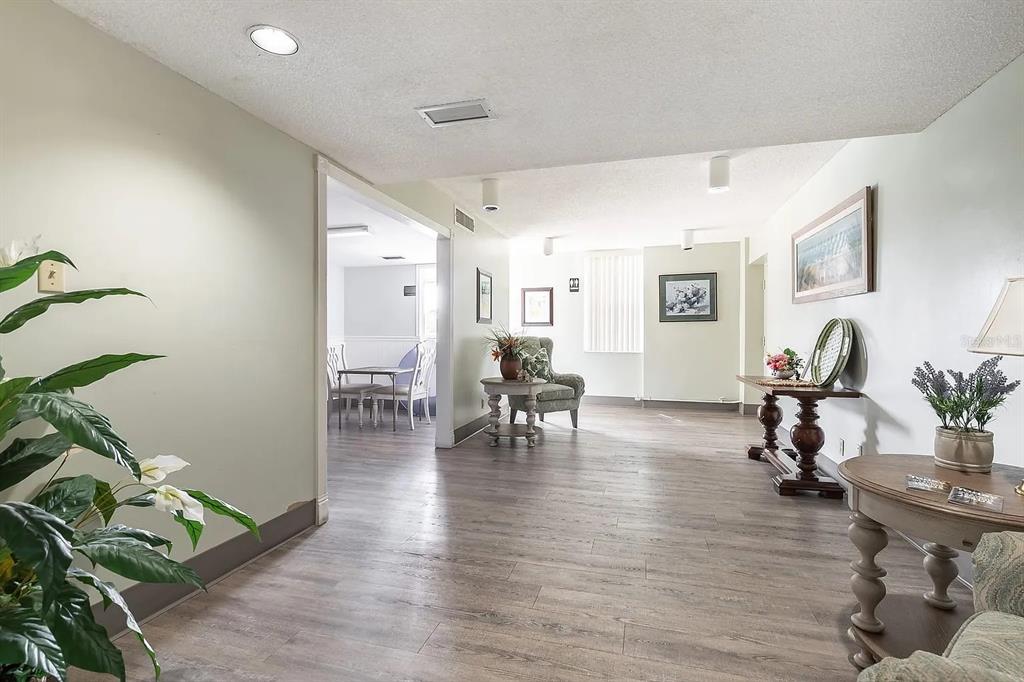 An empty bedroom features wood-look flooring, a ceiling fan, and white louvered closet doors — 2901 26TH STREET W UNIT 309, BRADENTON, FL