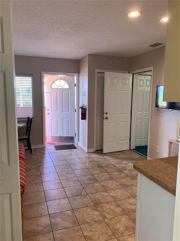 A tiled entryway leads to an open exterior door, a closet, and an interior doorway — 2777 N POINCIANA BOULEVARD UNIT 226G, KISSIMMEE, FL
