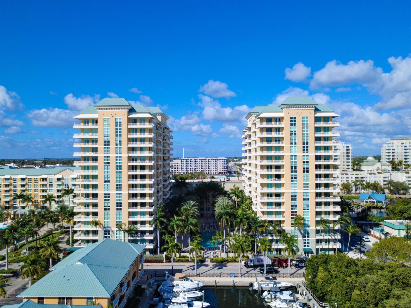 An aerial view shows two tall residential buildings flanking a pool area and a boat marina — 625 Casa Loma Boulevard # 1206, Boynton Beach FL 33435, BOYNTON BEACH, FL