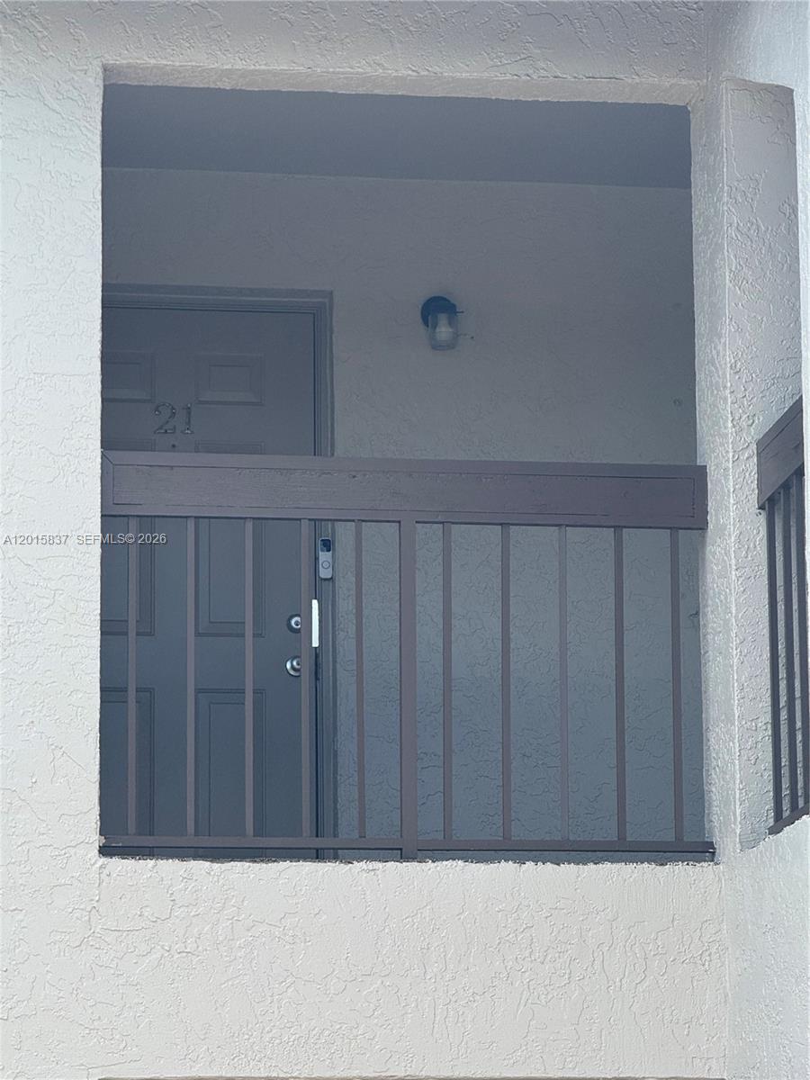 A dark gray front door with the number 21 is framed by a brown metal railing — 2221 E 5th street # 21, Lehigh Acres FL 33936, LEHIGH ACRES, FL