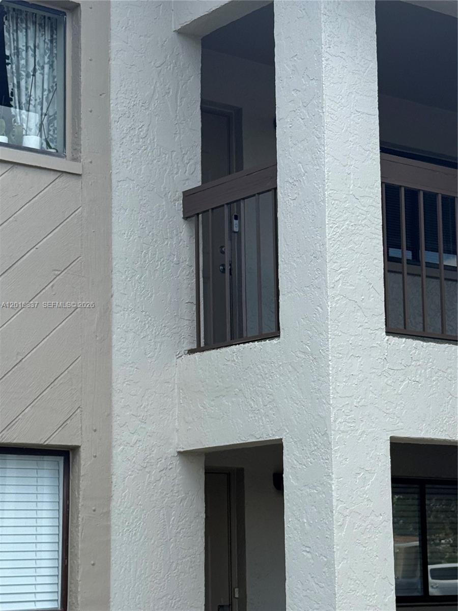 The exterior view shows a multi-story building with white stucco walls and brown metal railings — 2221 E 5th street # 21, Lehigh Acres FL 33936, LEHIGH ACRES, FL