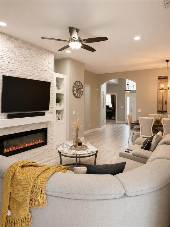 A living room features a stone fireplace, a sectional sofa, and an arched entryway — 9880 TIVOLI CHASE DRIVE, ORLANDO, FL