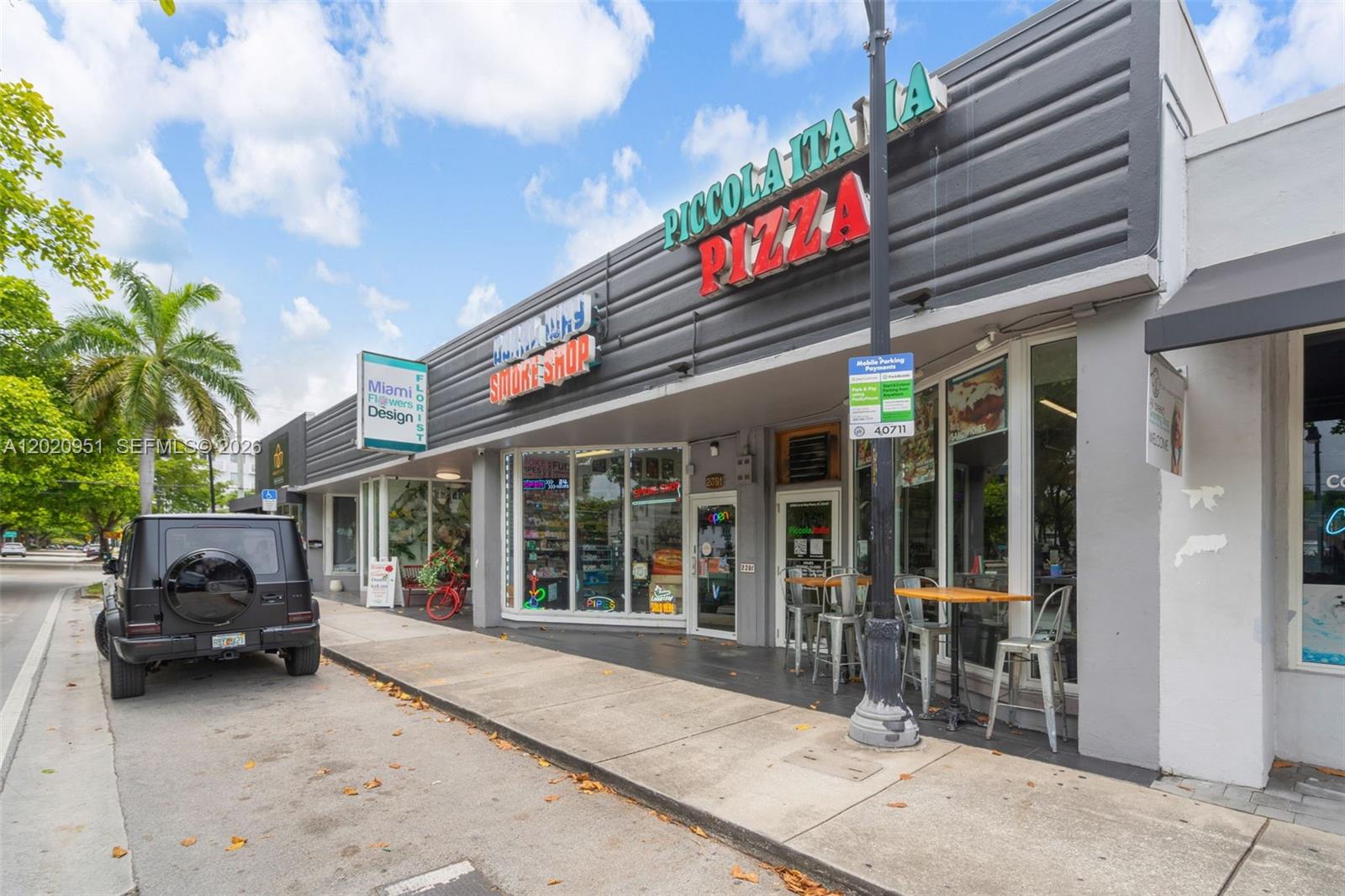 A street-level view shows a row of storefronts including a pizza restaurant and smoke shop — 2389 SW 22nd St, Miami FL 33145, MIAMI, FL