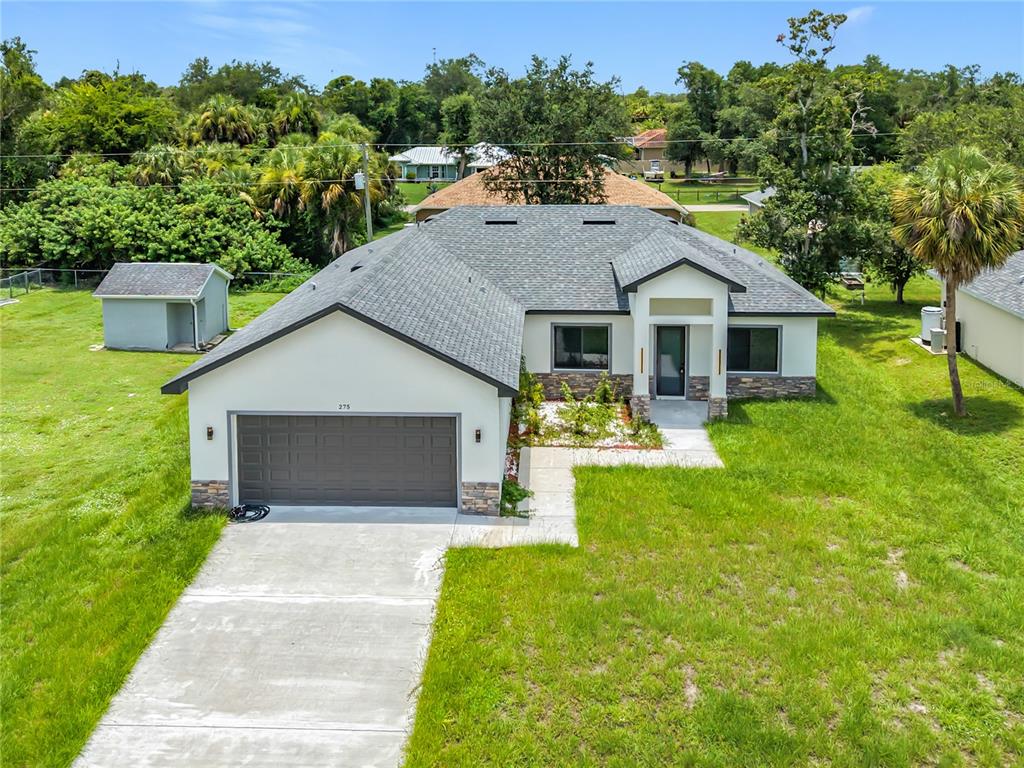 An aerial view of a single-story house with a gray roof, garage, and front yard — 275 LECTURN STREET, PORT CHARLOTTE, FL