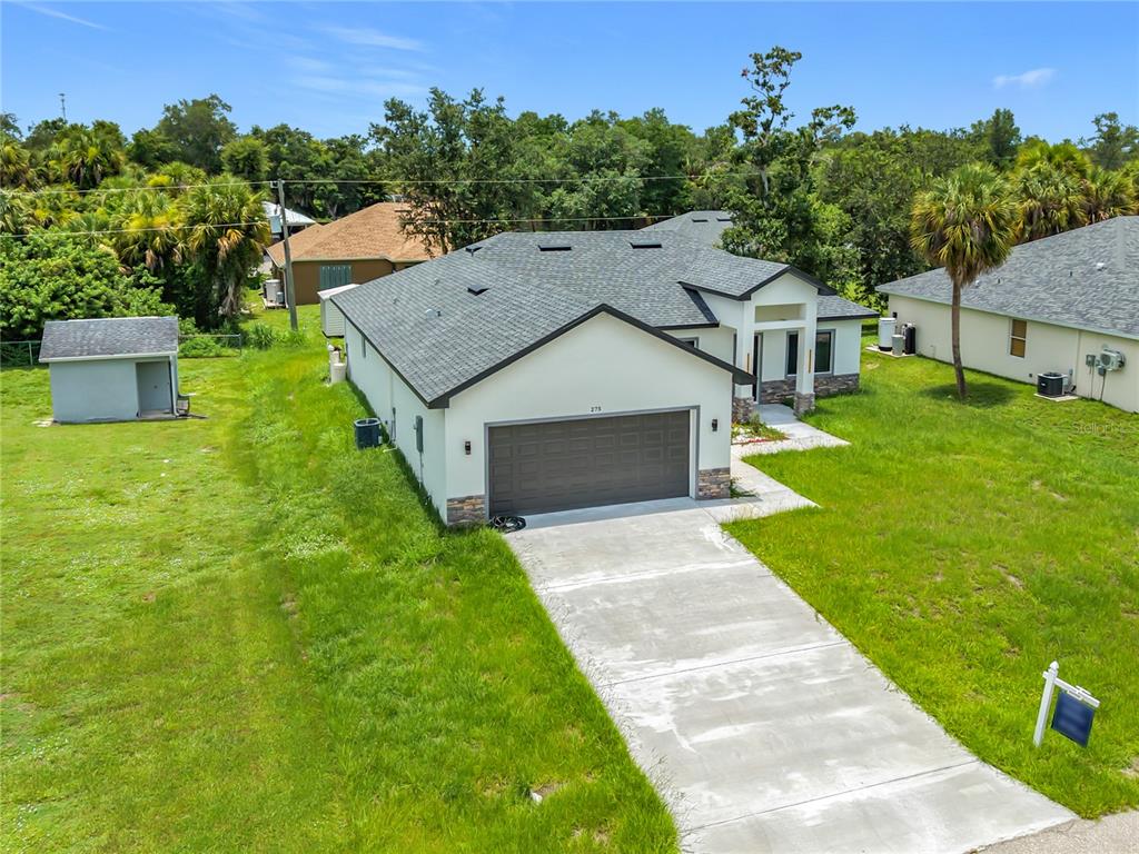 An aerial view shows a single-story house with a two-car garage and a concrete driveway — 275 LECTURN STREET, PORT CHARLOTTE, FL