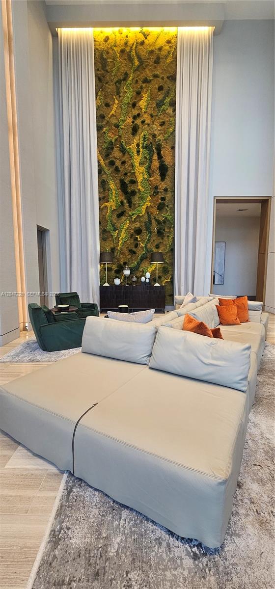 A living room features a tall moss wall, floor-to-ceiling curtains, and a large sectional sofa — 5350 NW 84th Ave # 507, Doral FL 33166, DORAL, FL