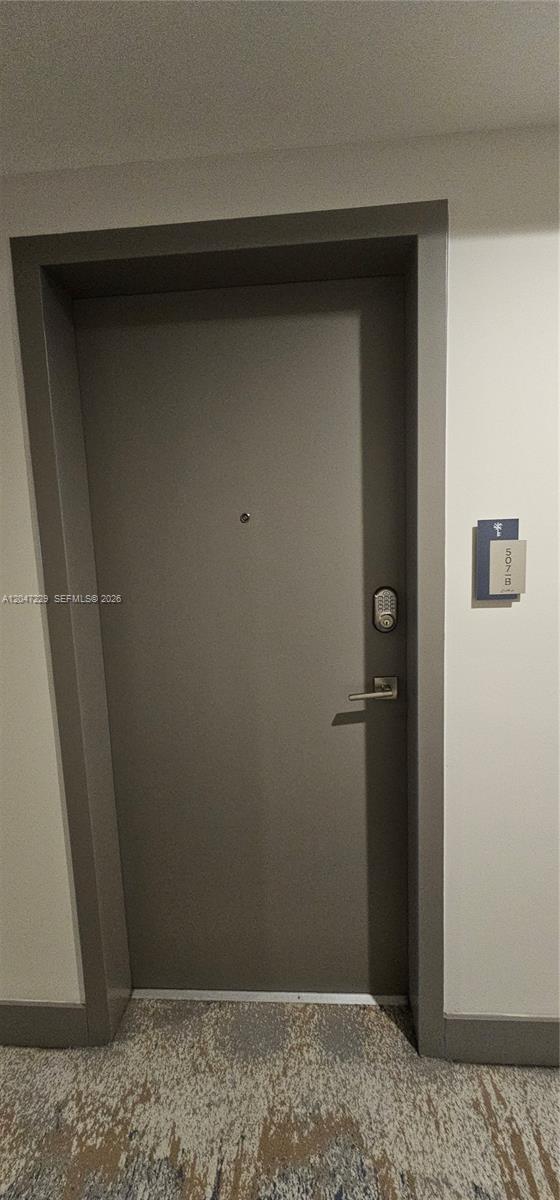 A gray apartment door with a digital lock and a unit number sign on the wall — 5350 NW 84th Ave # 507, Doral FL 33166, DORAL, FL
