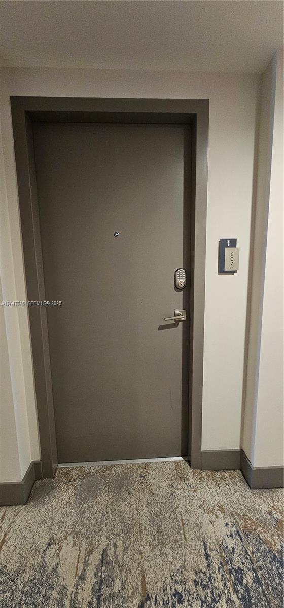 A gray apartment door with a digital keypad lock is numbered 507 in a hallway — 5350 NW 84th Ave # 507, Doral FL 33166, DORAL, FL
