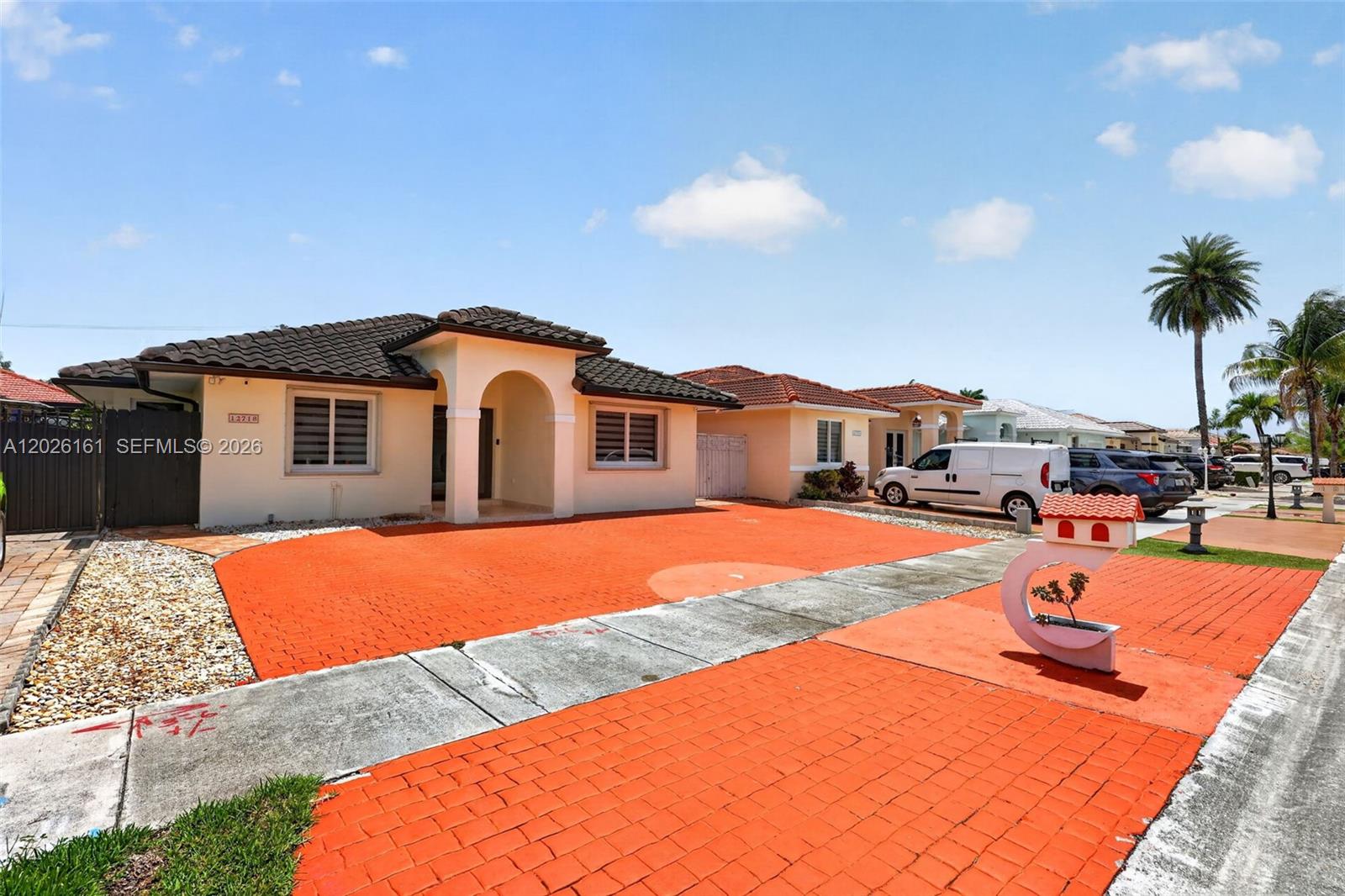 A single-story house with a tiled roof and an orange brick driveway under a blue sky — 12718 NW 6th Ln, Miami FL 33182, MIAMI, FL