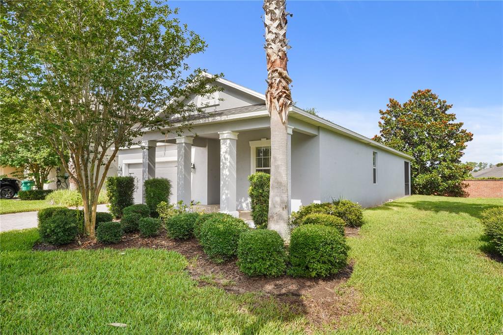 A single-story gray house with a covered front porch and a palm tree — 1950 PANTHEON DRIVE, WINTER GARDEN, FL