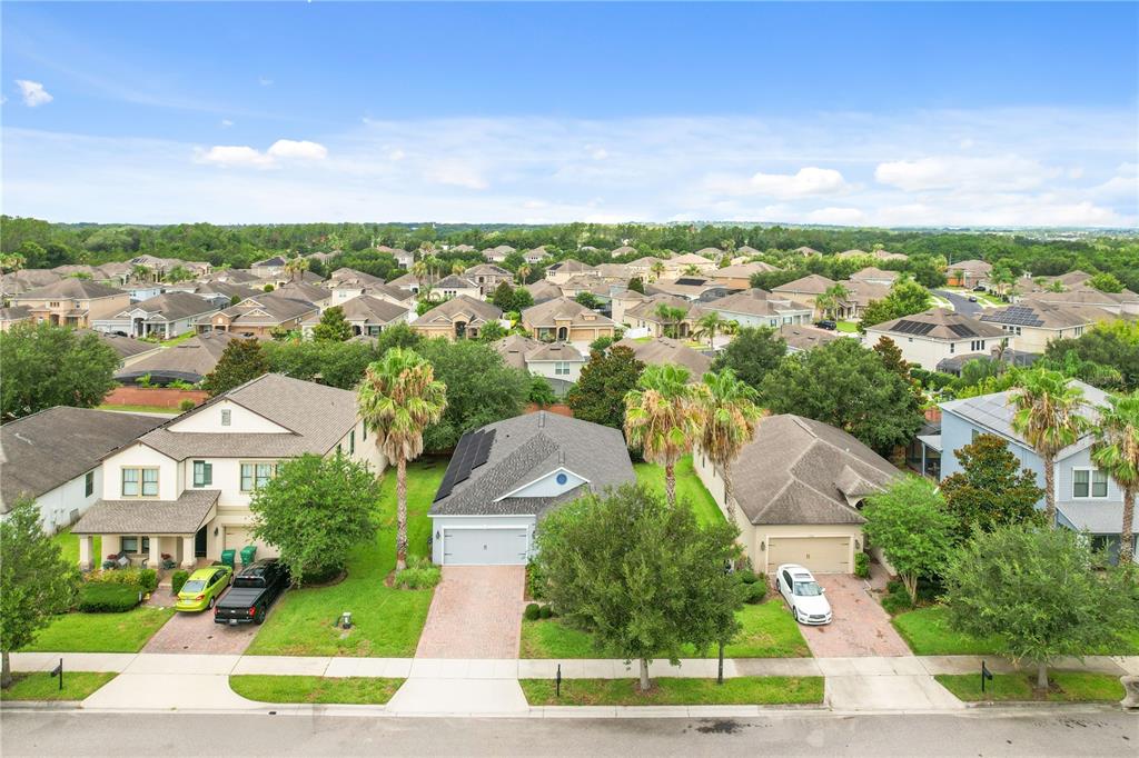 An aerial view shows three suburban houses with driveways and lawns on a residential street — 1950 PANTHEON DRIVE, WINTER GARDEN, FL