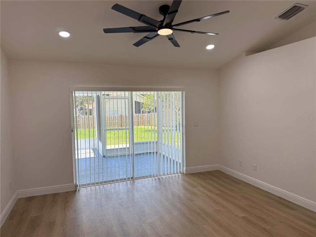 A room with light wood-look flooring, a ceiling fan, recessed lighting, and sliding glass doors — 245 CHARDONNAY PLACE, VALRICO, FL