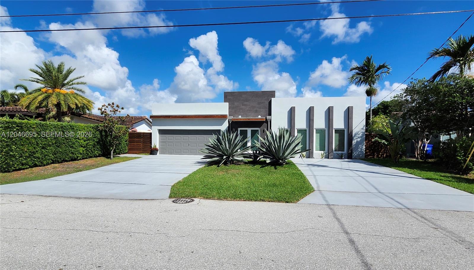 A modern single-story house features a gray garage, dark stone accent wall, and concrete driveway — 966 SE 9th Ave, Pompano Beach FL 33060, POMPANO BEACH, FL