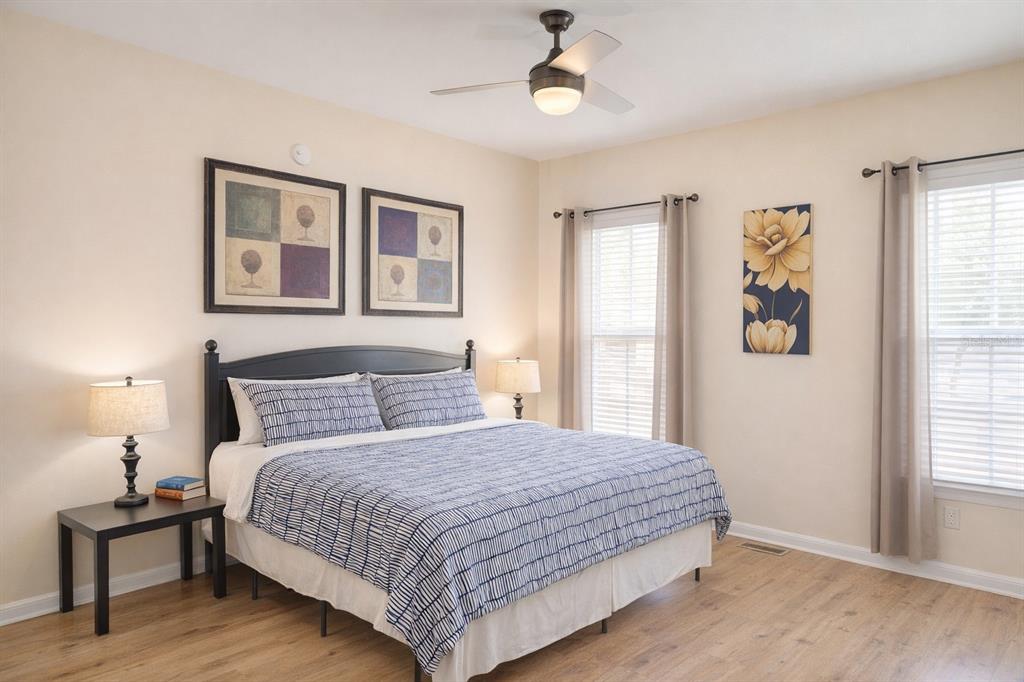A bedroom features a king bed, two windows, a ceiling fan, and light wood flooring — 501 S MAGNOLIA AVENUE UNIT 1, TAMPA, FL
