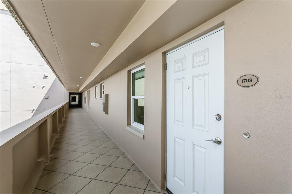 A white apartment door with number 1708 is located on an outdoor tiled walkway — 5200 BRITTANY DRIVE S UNIT 1708, ST PETERSBURG, FL
