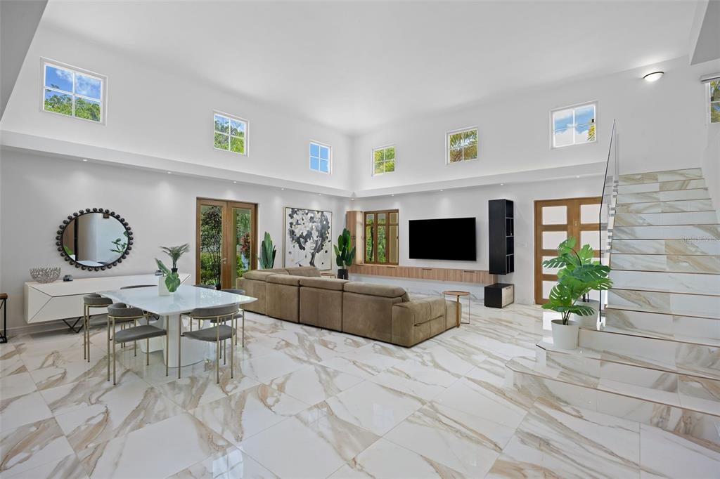 A spacious living room features high ceilings, marble-look tile floors, a sectional sofa, and stairs — 415 CAMINO DEL SUSUA, DORADO, PR