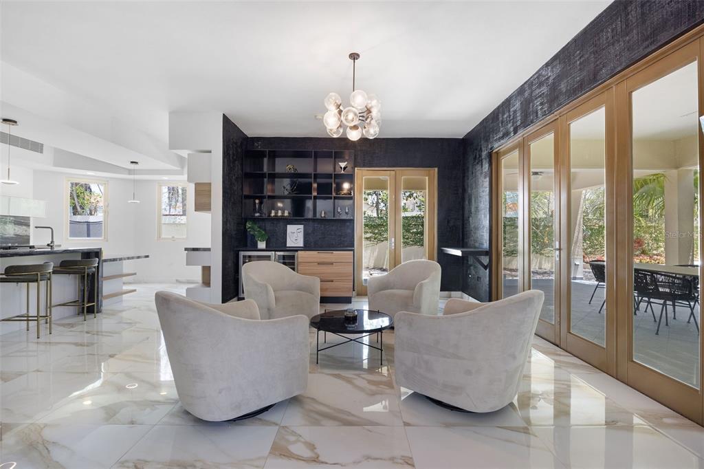 A modern living area features four cream armchairs, a dark accent wall, and marble flooring — 415 CAMINO DEL SUSUA, DORADO, PR