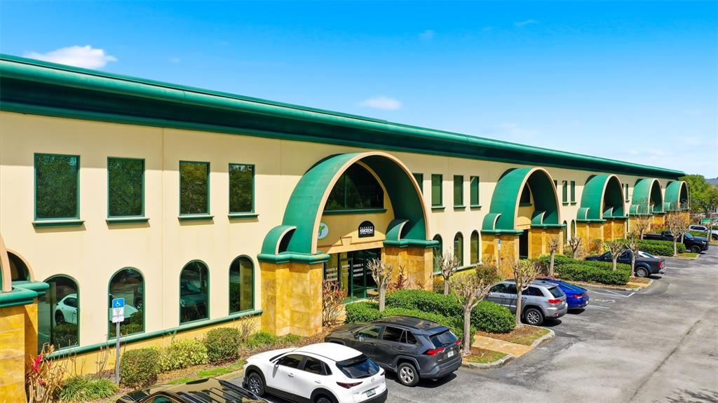 A low-rise commercial building with green arched accents and a parking lot in front — 6881 KINGSPOINTE PARKWAY UNIT 3, ORLANDO, FL