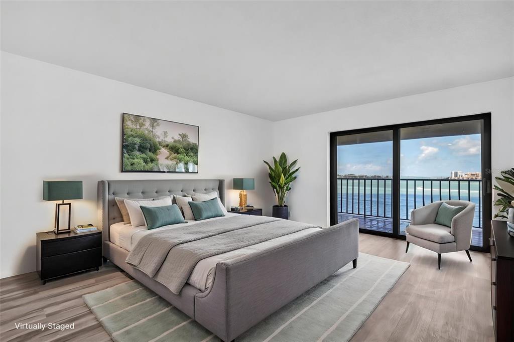 A bedroom with a gray bed, light wood floors, and a balcony overlooking the water — 55 ROGERS STREET UNIT P5, CLEARWATER, FL