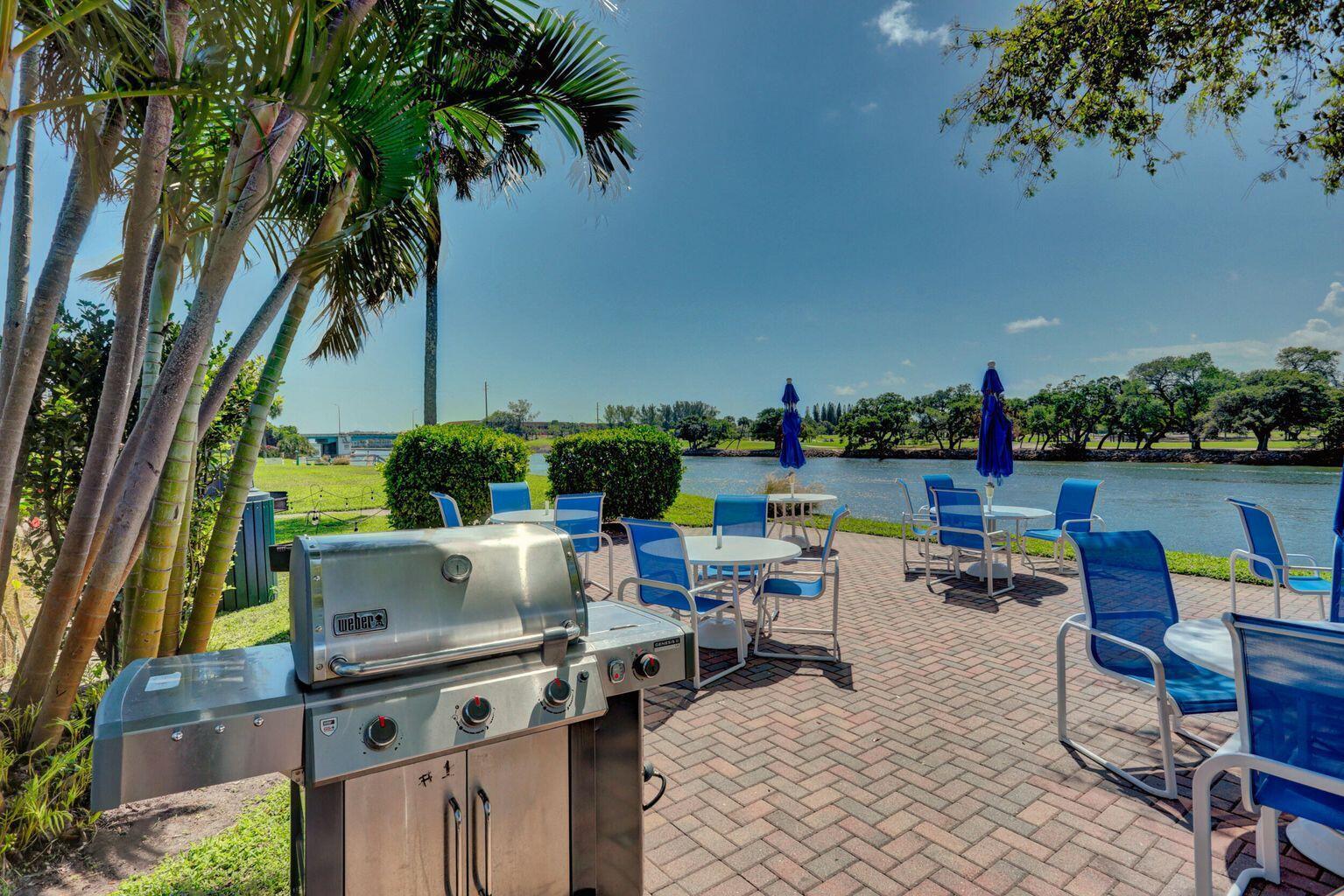 A stainless steel grill sits on a brick patio overlooking a river with outdoor seating — 336 Golfview Road # 203, North Palm Beach FL 33408, NORTH PALM BEACH, FL