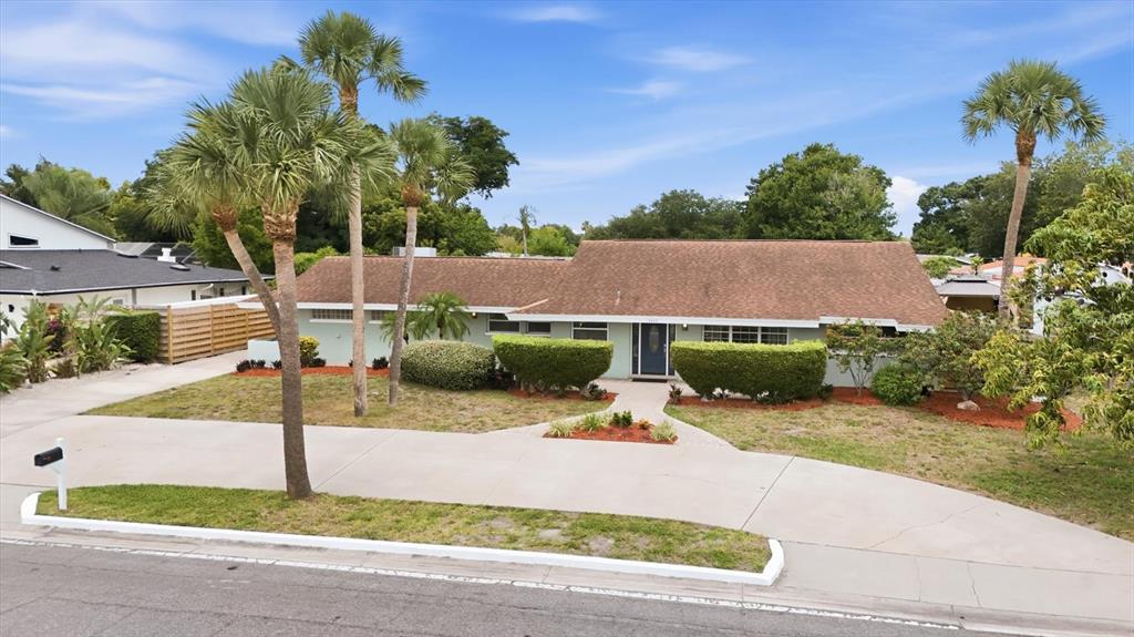 A single-story house with a brown roof, light green siding, and palm trees in front — 3612 S LOCKWOOD RIDGE ROAD, SARASOTA, FL