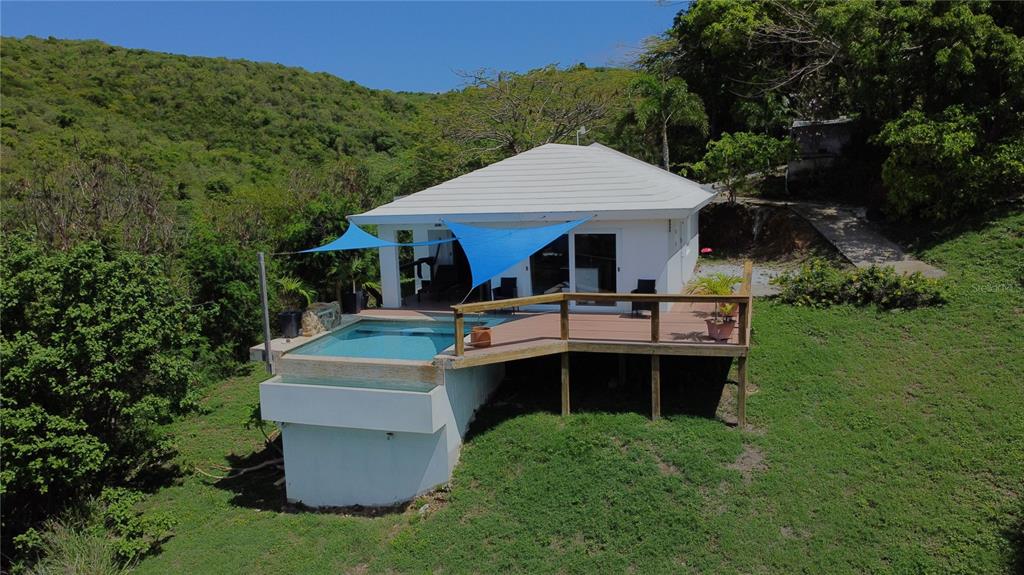 An elevated white house features a wooden deck with a small infinity pool and shade sails — 5R MOUNT RESACA BARRIO FLAMENCO, CULEBRA, PR