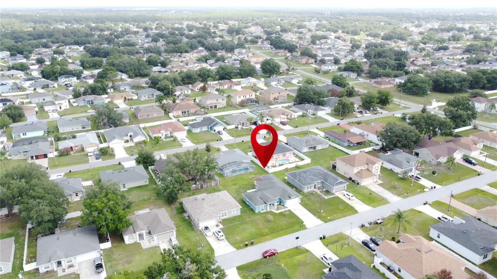 An aerial view shows a residential neighborhood with a red location pin marking a house — 413 FLAMINGO CT, POINCIANA, FL