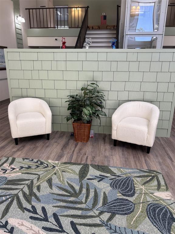Two white chairs and a potted plant sit before a light green shingled wall — 21267 GERTRUDE AVENUE UNIT 112, PORT CHARLOTTE, FL