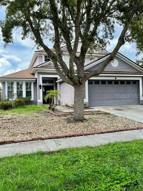 A two-story suburban house with a gray garage and a large tree in the front yard — 419 HALIFAX BAY COURT, APOLLO BEACH, FL
