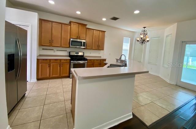 A kitchen with light wood cabinets, stainless steel appliances, and a central breakfast bar island — 419 HALIFAX BAY COURT, APOLLO BEACH, FL