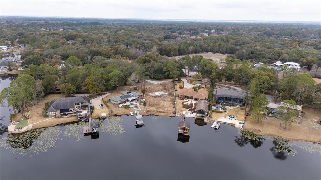 An aerial view shows several waterfront homes with private docks along a lake — 601 TUSCANY COURT, SANFORD, FL