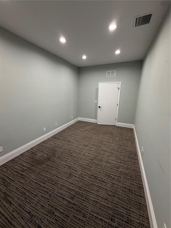 An empty room with light blue walls, recessed lighting, and patterned brown carpeting — 5182 N OCEAN SHORE BOULEVARD UNIT A-2, PALM COAST, FL