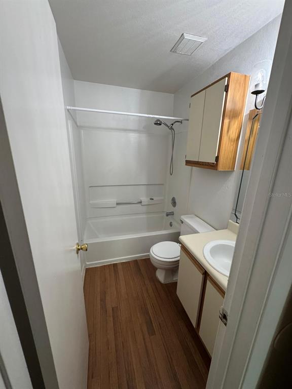 A bathroom features a tub-shower combination, a toilet, and a vanity with wood-look flooring — 956 SALT POND PLACE UNIT 304, ALTAMONTE SPRINGS, FL