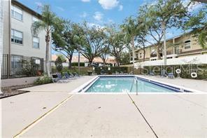 A rectangular swimming pool is surrounded by a concrete deck and multi-story apartment buildings — 956 SALT POND PLACE UNIT 304, ALTAMONTE SPRINGS, FL